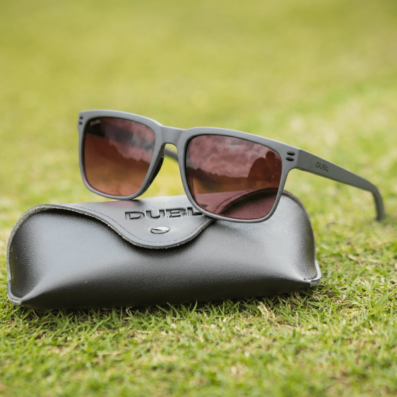 Gray | Sunglasses with a black frame and red lenses on a black case