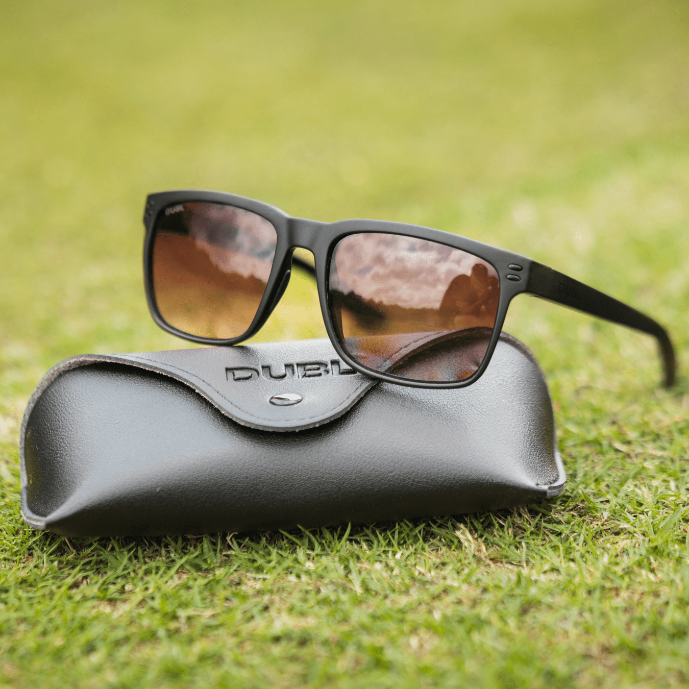 Black | Sunglasses with a black frame and red lenses on a black case