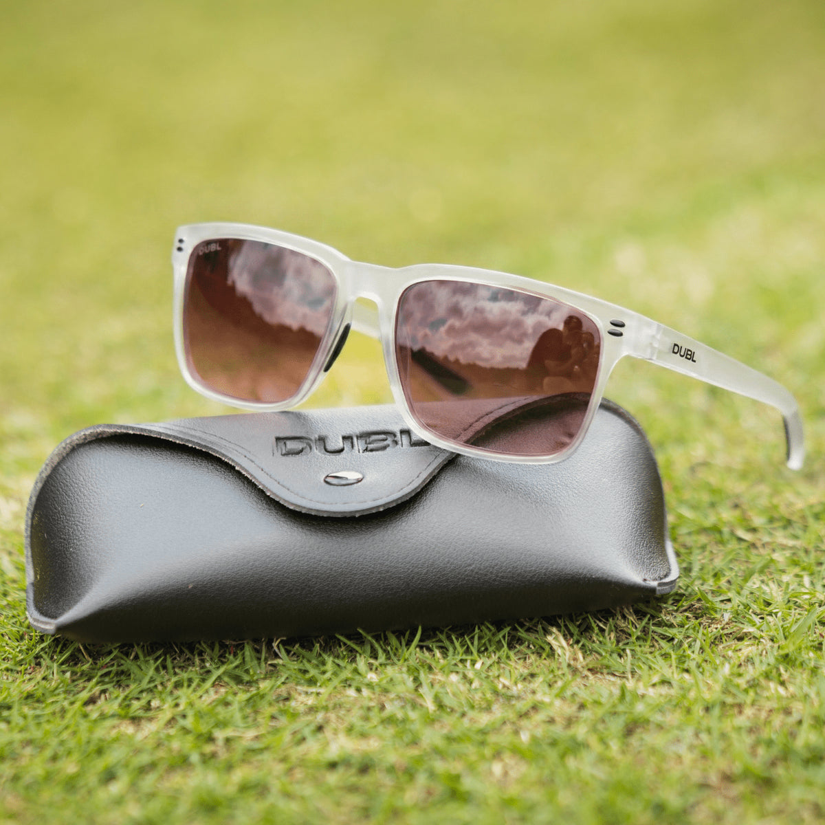 Matte Halo | Sunglasses with a black frame and red lenses on a black case