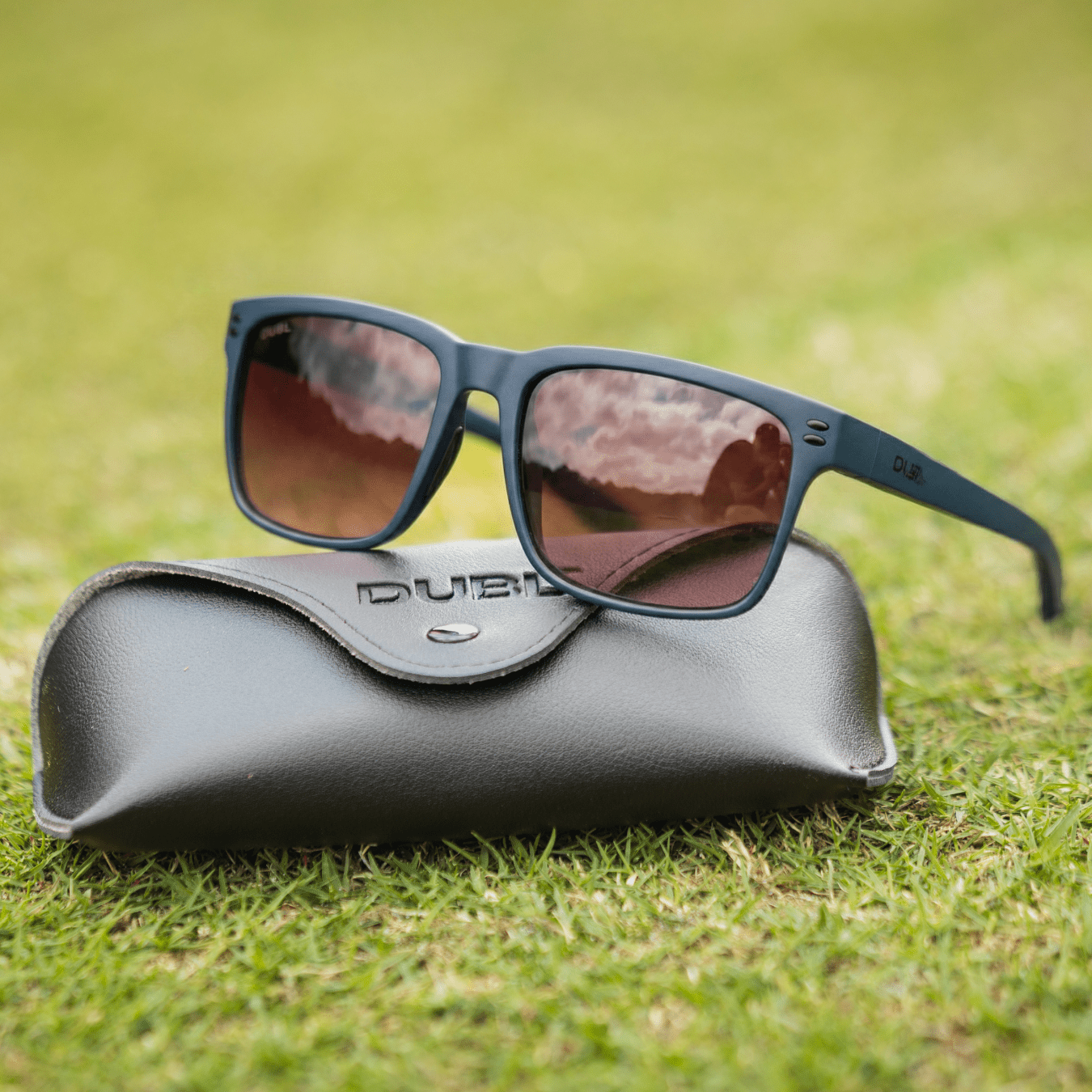 Navy | Sunglasses with a black frame and red lenses on a black case