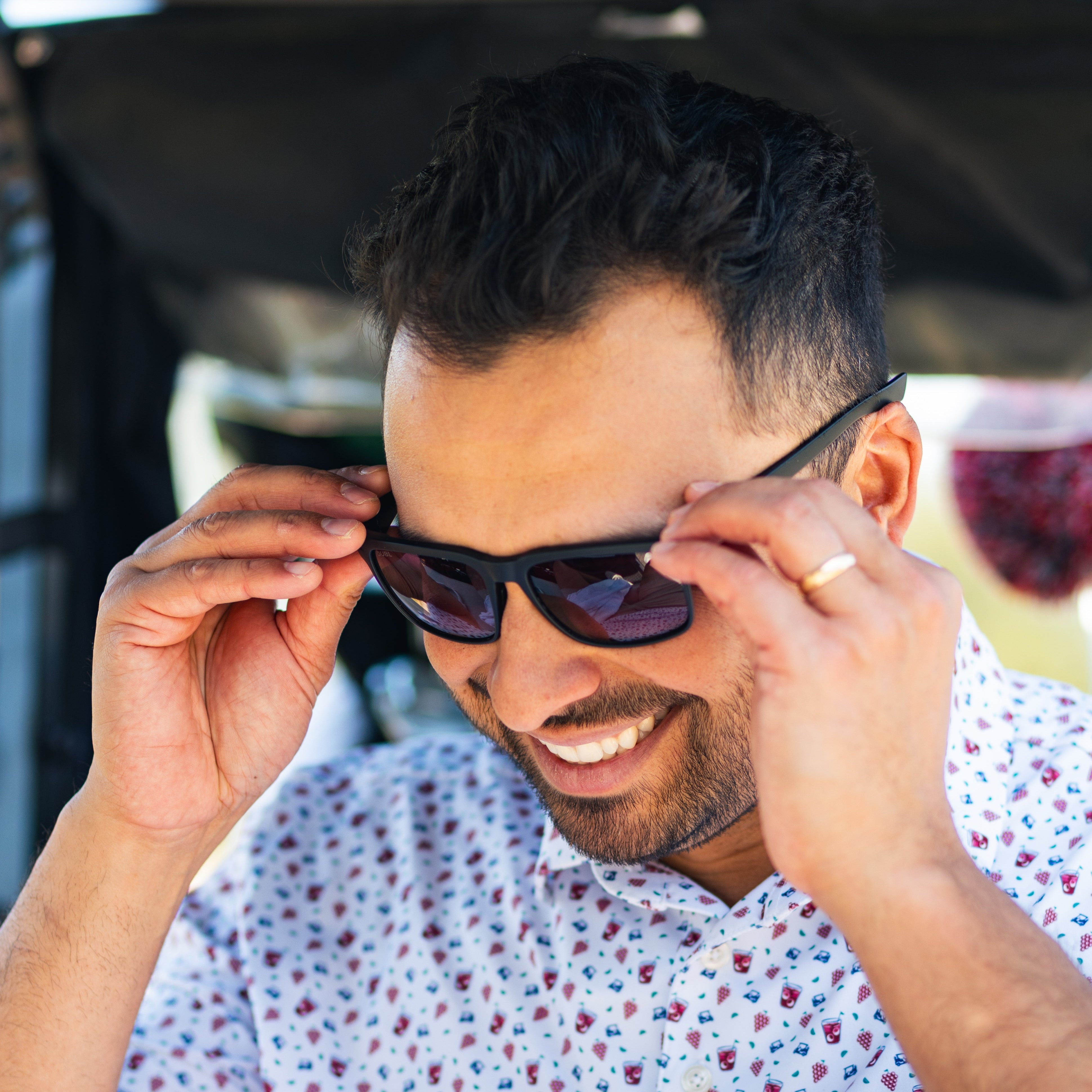 Man adjusting golf sunglasses and smiling