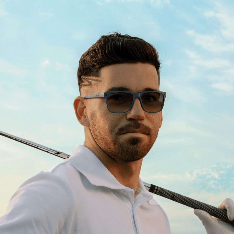 Matte Abyss | Man wearing golf sunglasses holding a golf club on a golf course with a clear sky
